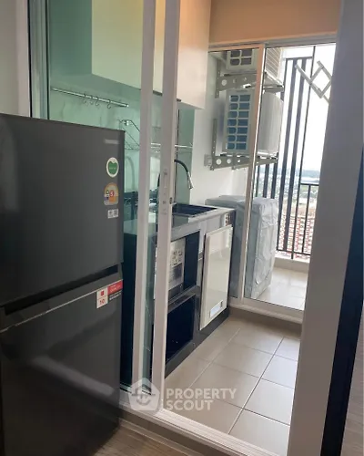 Modern kitchen with balcony view, featuring sleek appliances and ample natural light.