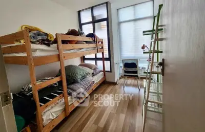 Cozy bedroom with bunk beds and study area, perfect for maximizing space in a modern apartment.