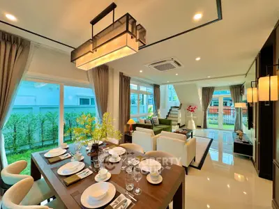 Luxurious open-plan living and dining area with modern decor and garden view.