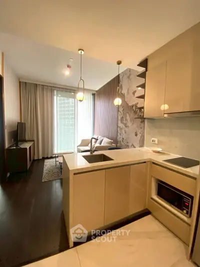 Modern open-layout kitchen with sleek cabinetry and cozy living area in a stylish apartment.