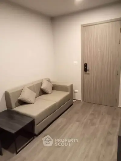 Cozy living room with modern sofa and wooden flooring in a stylish apartment.