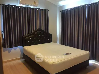 Cozy bedroom with elegant bed and dark curtains, perfect for restful nights.