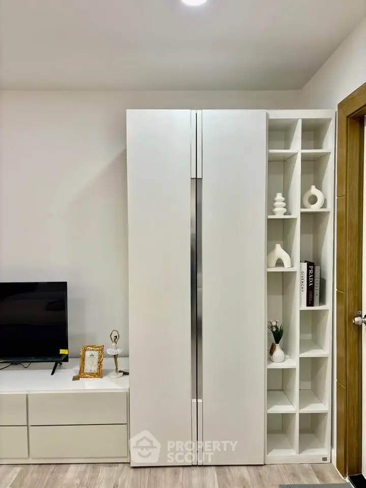 Modern living room with sleek white storage and TV unit, perfect for stylish urban living.