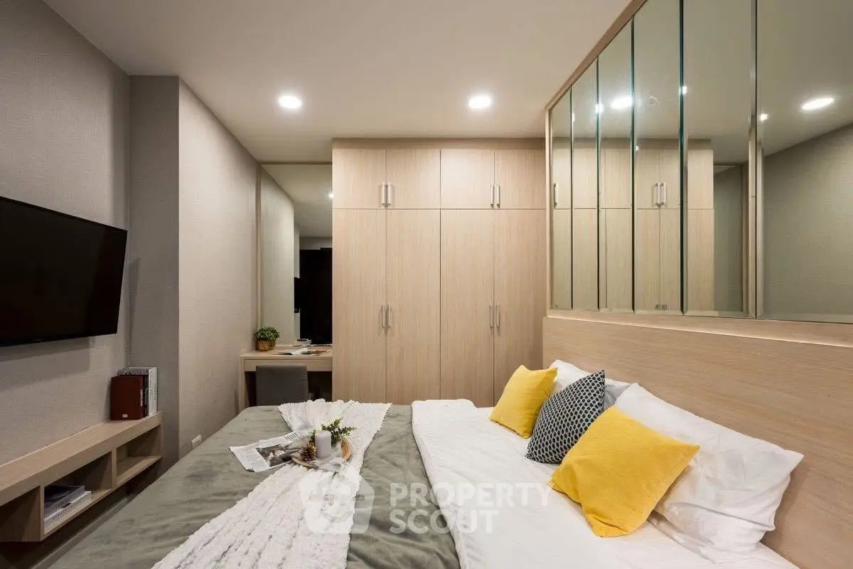 Modern bedroom with stylish decor and ample storage, featuring cozy bedding and elegant lighting.