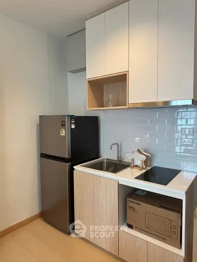 Modern compact kitchen with sleek appliances and stylish cabinetry