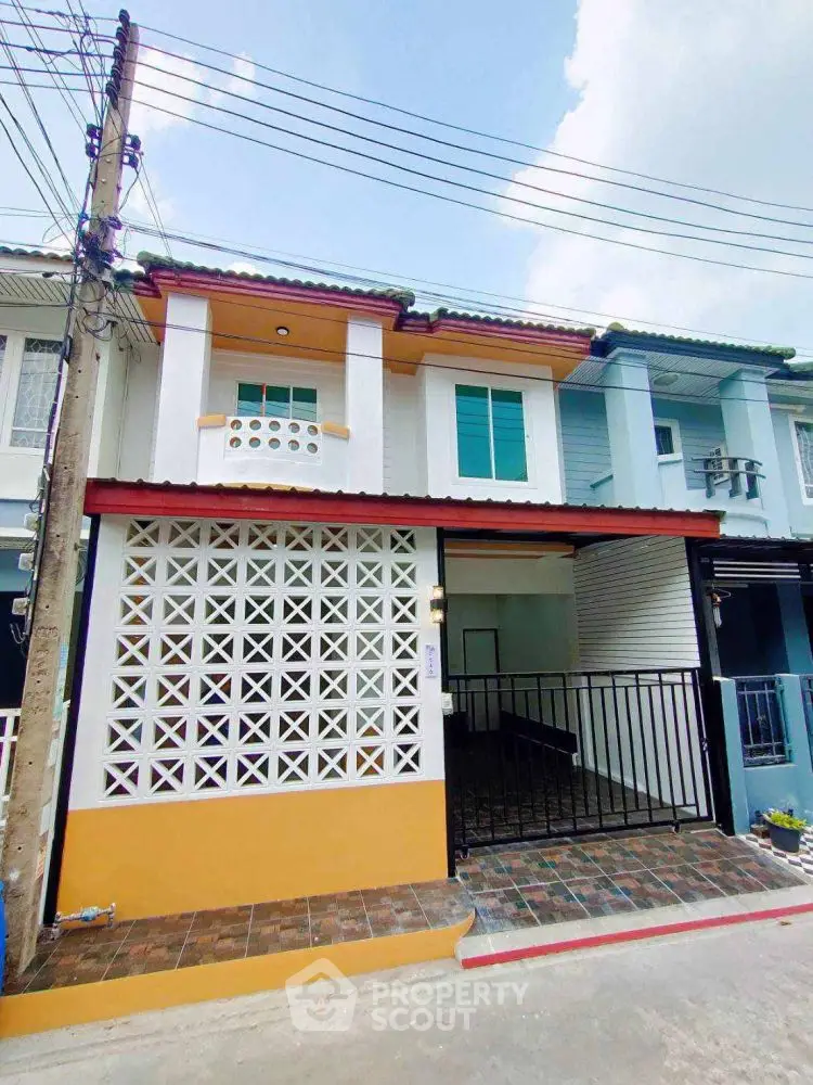 Charming two-story townhouse with modern facade and gated entrance in a vibrant neighborhood.