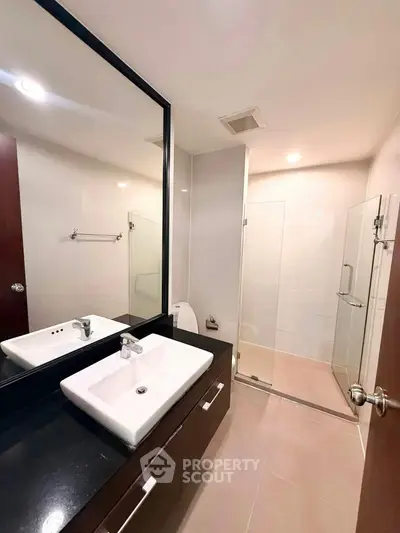 Modern bathroom with sleek fixtures and glass shower enclosure