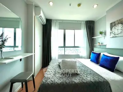 Modern bedroom with large window and stylish decor in a high-rise apartment.
