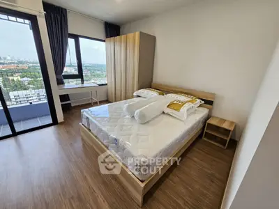 Modern bedroom with large window and city view, featuring a comfortable bed and wooden flooring.