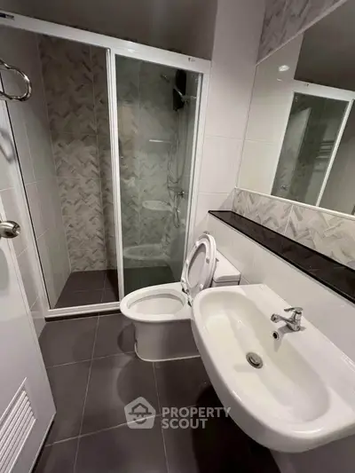 Modern bathroom with sleek shower and elegant fixtures in contemporary apartment.