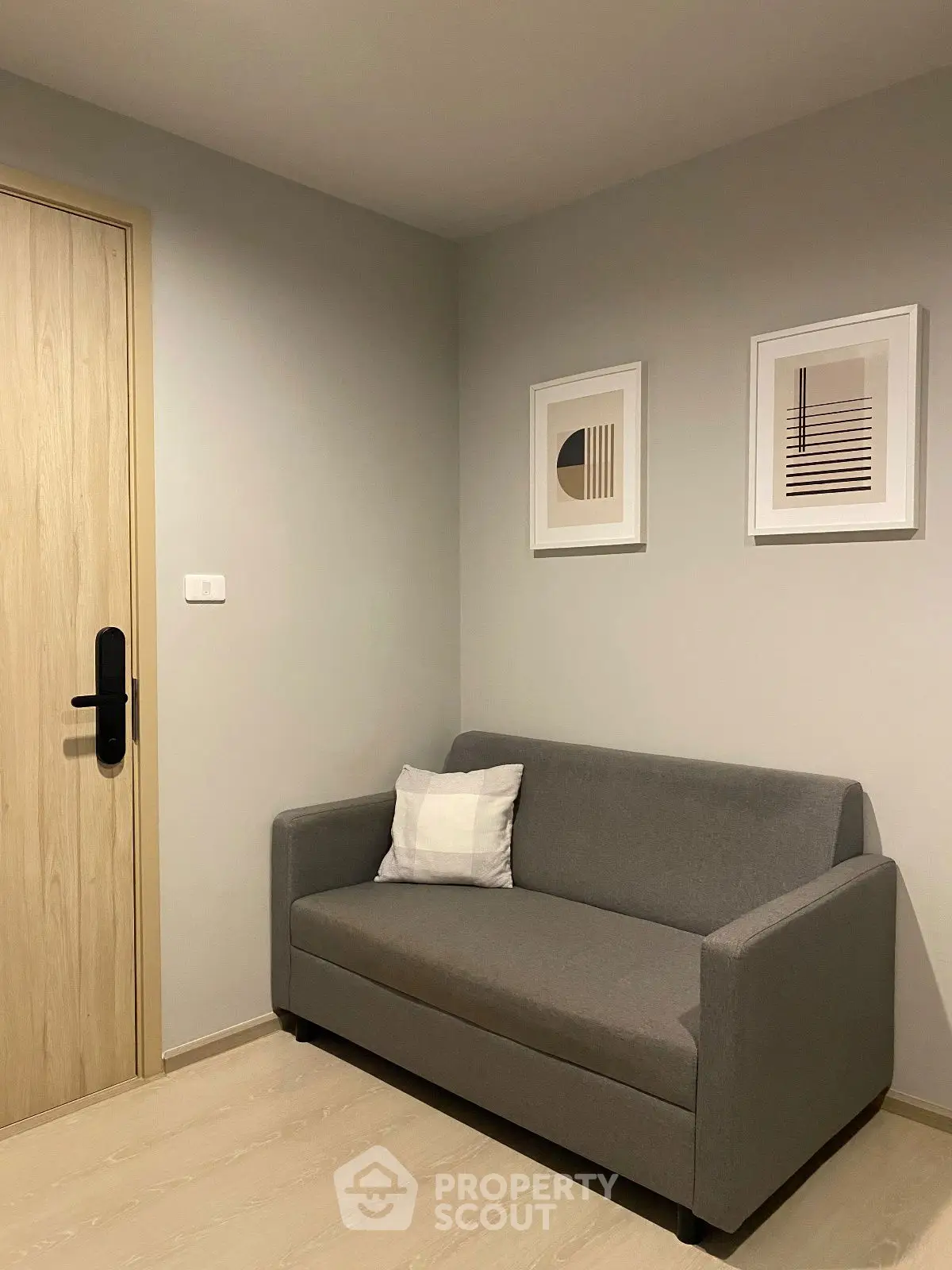 Cozy modern living room with gray sofa and minimalist wall art.