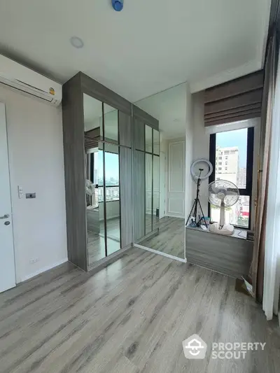 Modern bedroom with mirrored wardrobe and city view