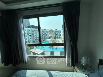 Spacious bedroom with stunning pool view in modern apartment complex