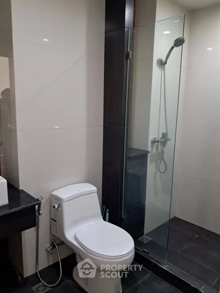 Modern bathroom with glass shower and sleek fixtures in a contemporary home.