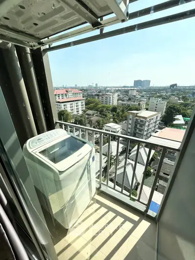 High-rise balcony with washing machine and cityscape view