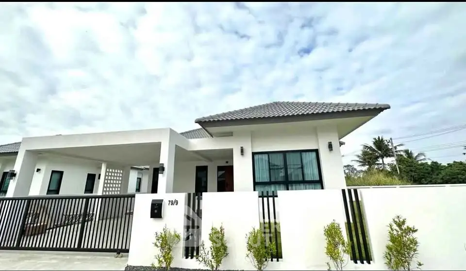 Modern single-story house with sleek design and spacious driveway in a serene neighborhood.
