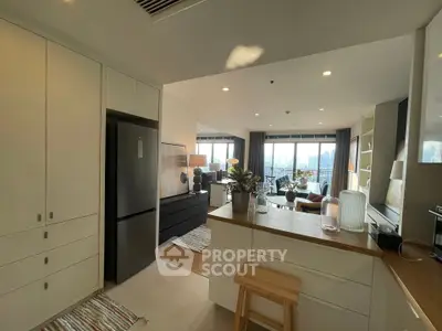 Modern open-plan kitchen and living room with city view, stylish decor, and natural light.