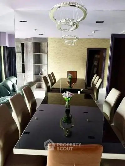 Elegant dining room with modern chandelier and mirrored wall, perfect for stylish gatherings.