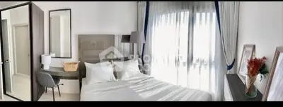 Bright and airy bedroom with modern decor and large window view.