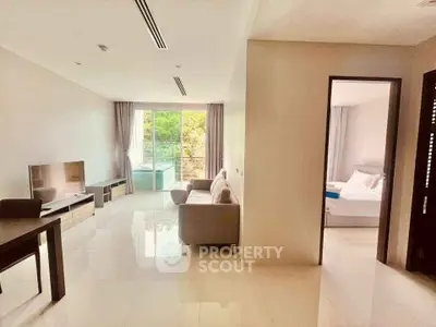 Spacious modern living room with natural light and adjacent bedroom in luxury apartment.