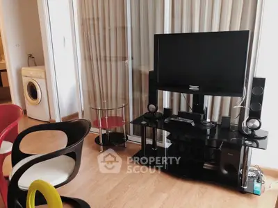 Modern living room with sleek TV stand, stylish chairs, and washing machine in the background.