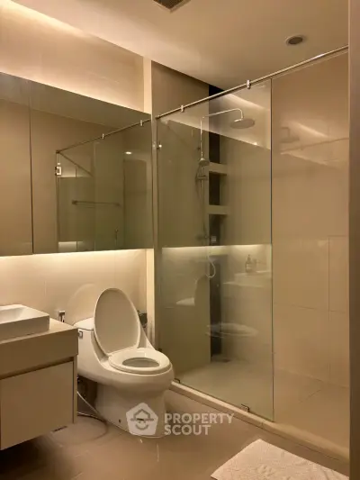 Modern bathroom with glass shower enclosure and sleek fixtures