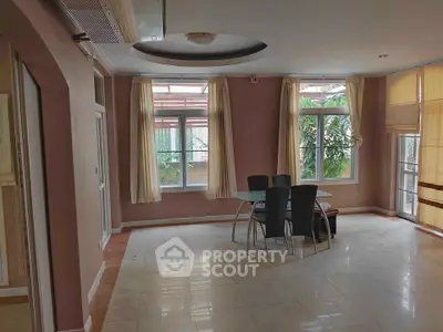 Spacious living room with large windows and modern dining set