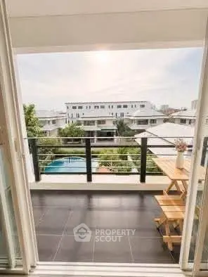 Stunning balcony view with modern railing overlooking pool and residential area.