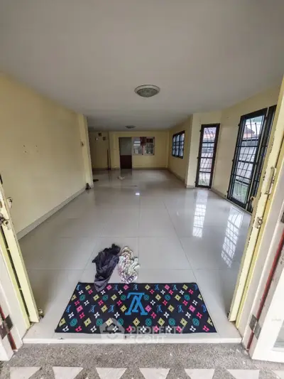 Spacious empty room with tiled flooring and large windows for natural light