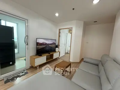 Modern living room with sleek furniture and large TV, perfect for relaxation.