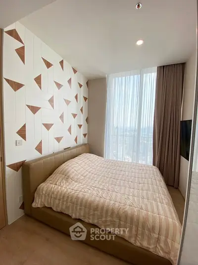 Modern bedroom with stylish geometric accent wall and large window view.