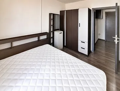 Spacious bedroom with modern furniture and wooden flooring