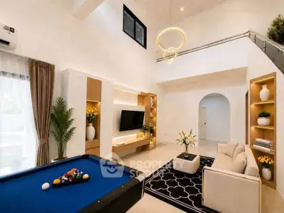Luxurious living room with high ceilings, pool table, and modern decor