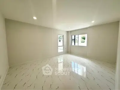 Spacious and bright living room with elegant marble flooring and large windows.