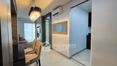 Modern living room with elegant chandelier and cozy seating area in a stylish apartment.