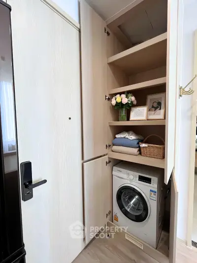 Modern laundry nook with washing machine and stylish shelving in compact apartment