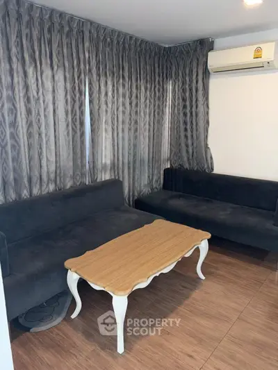 Cozy living room with elegant wooden coffee table and plush sofas, perfect for relaxation.