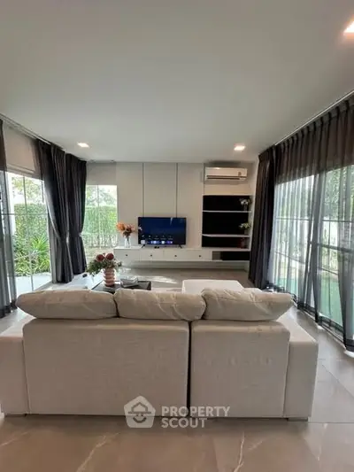 Spacious living room with modern decor and large windows for natural light.