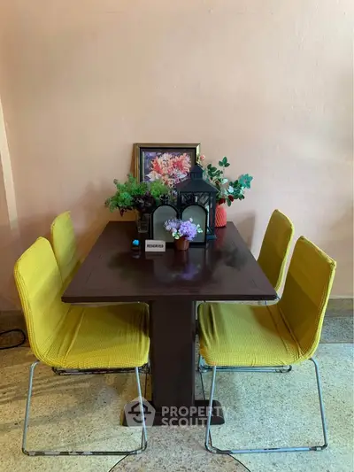 Charming dining area with vibrant yellow chairs and elegant decor, perfect for cozy gatherings.