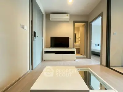 Modern living room with sleek design and neutral tones, featuring a TV and air conditioning.