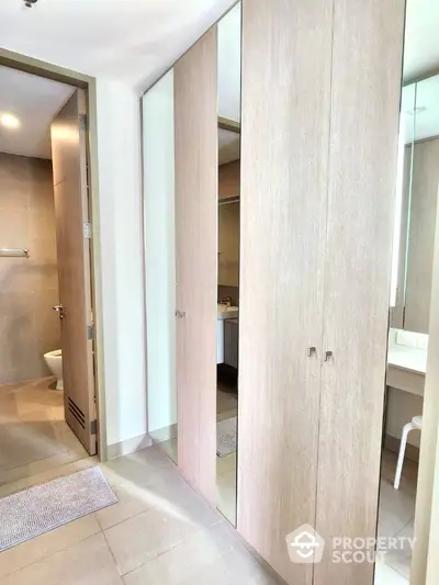 Modern bathroom with sleek wooden cabinets and large mirrors