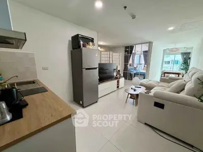 Modern open-plan living room with cozy seating and sleek kitchen area