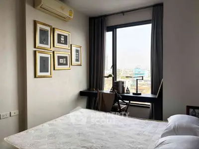 Cozy bedroom with city view, featuring elegant wall art and a sleek desk by the window.