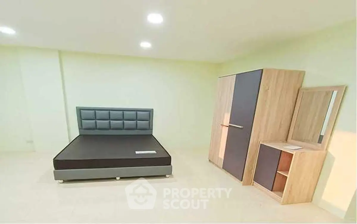 Spacious bedroom with modern bed and wardrobe in minimalist design.