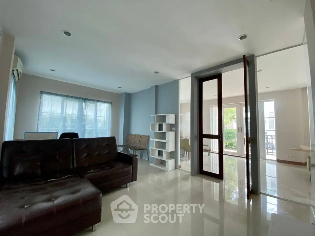 Spacious modern living room with sleek furniture and large windows for natural light.