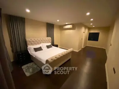 Spacious bedroom with elegant bed and ambient lighting, perfect for relaxation.