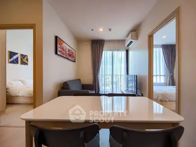 Modern apartment interior with open living room and dining area, featuring stylish decor and natural light.