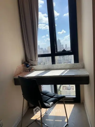 Cozy study nook with city view, featuring a sleek desk and comfortable chair by a large window.