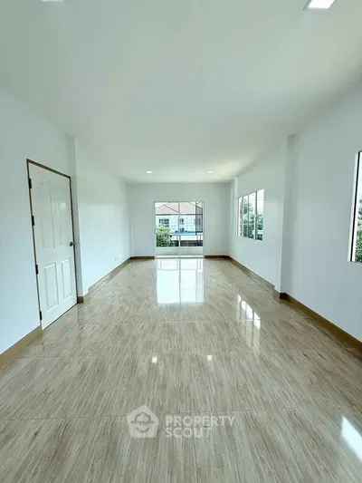 Spacious empty room with large windows and glossy wooden flooring, perfect for customization.