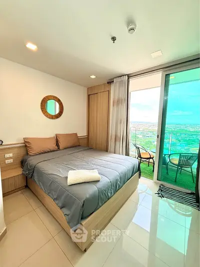 Modern bedroom with balcony offering stunning city views, featuring sleek design and cozy ambiance.